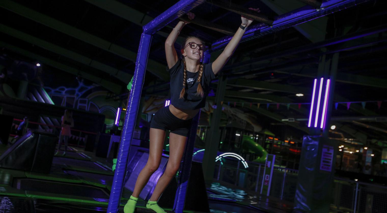 A girl traverses the Monkey Bars at Flip Out UK