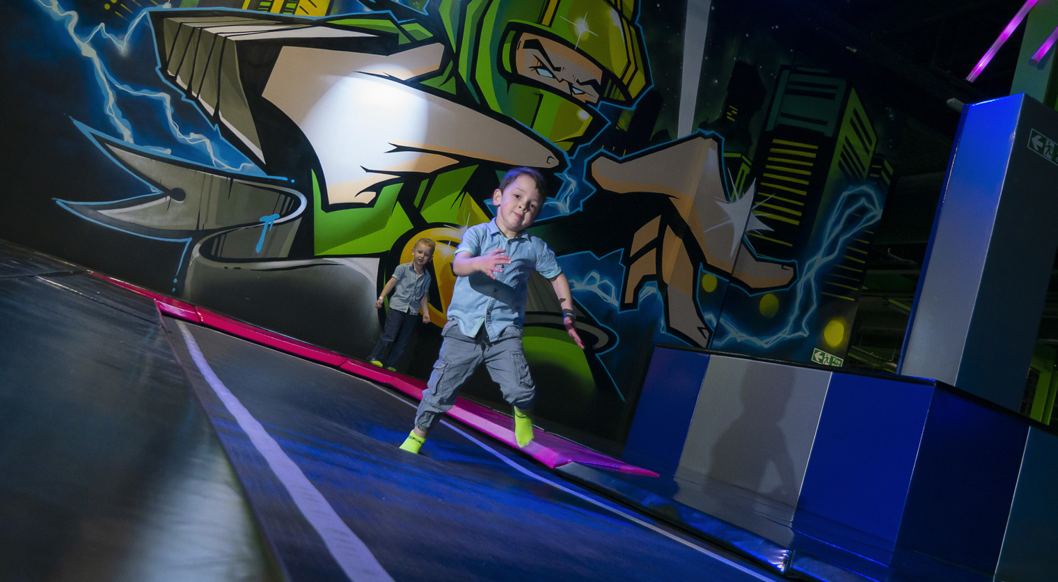 A young child running along the Tumble Tracks at Flip Out UK