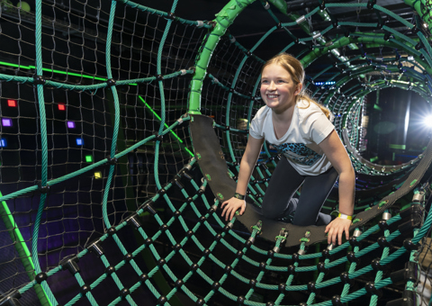 A child crawling through the Ninja Tag arena at Flip Out UK