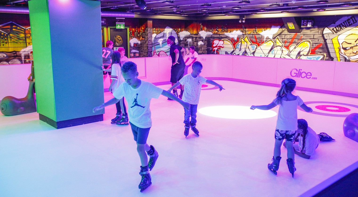 Children in skates enjoying the Synthetic Ice Rink at Flip Out UK