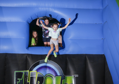 A child leaping into Free Fall on an inflatable at Flip Out UK