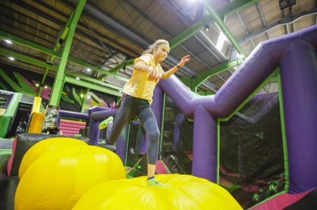 A child attempting to cross the Wipeout course at Flip Out UK